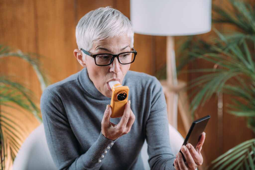 Woman doing a lung function test at home