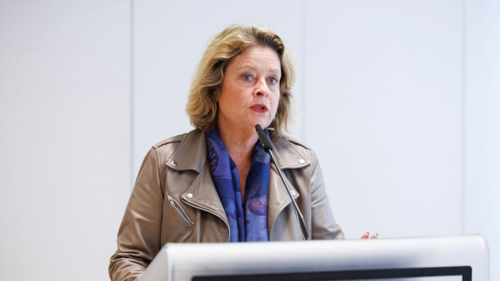 Stinne Bosse MEP, Vice-Chair of the SANT Subcommittee, speaking during healthy lungs for life exhibition at the European Parliament. She is wearing an earth tone leather jacket with a blue scarf. She is standing behind a lectern with a microphone.