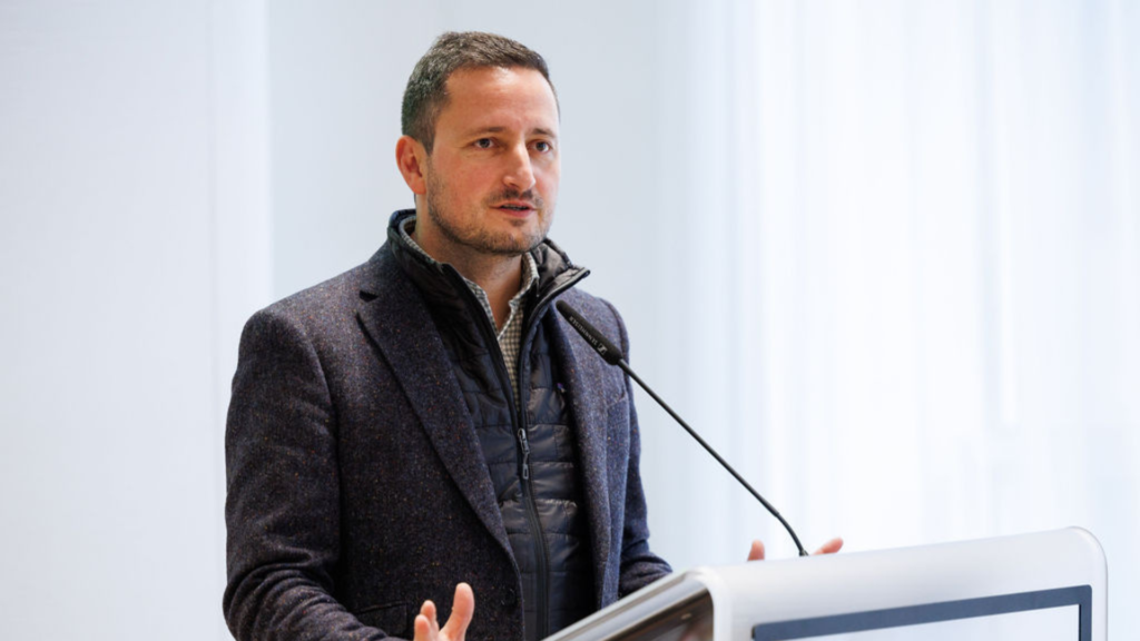 Vice-President of the European Parliament Nicolae Ștefănuță, speaking during healthy lungs for life exhibition at the European Parliament. He is wearing a dark grey gilet and blazer. He is standing behind a lectern with a microphone.