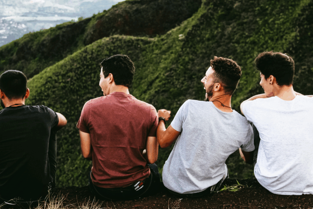 A group of teenage boys sat looking at a view of the hills